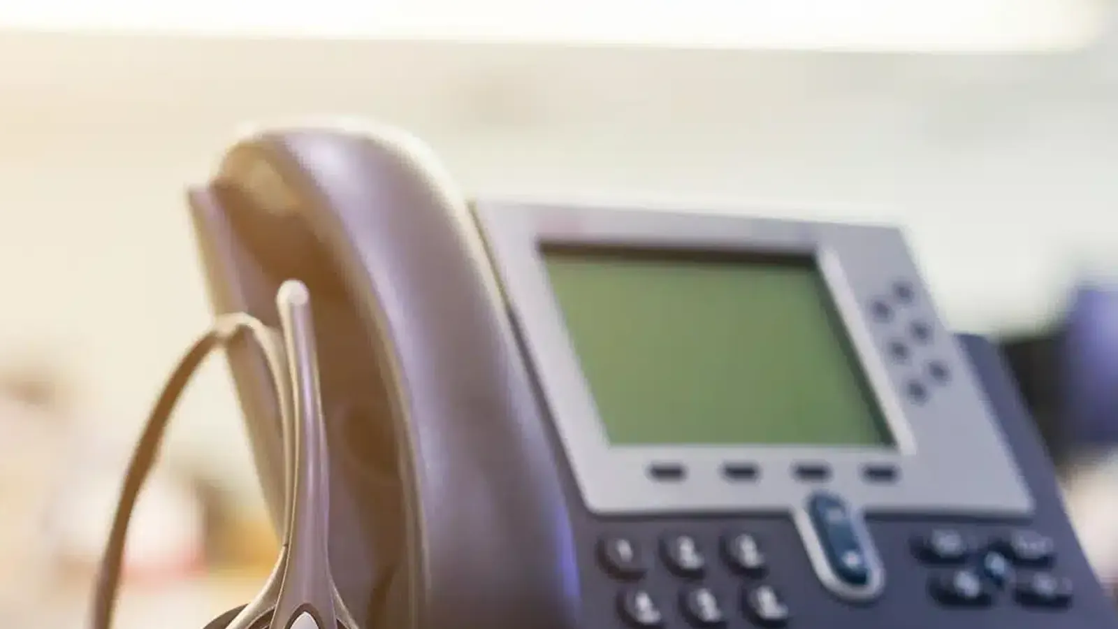 IP desk phone with headset on an office desk