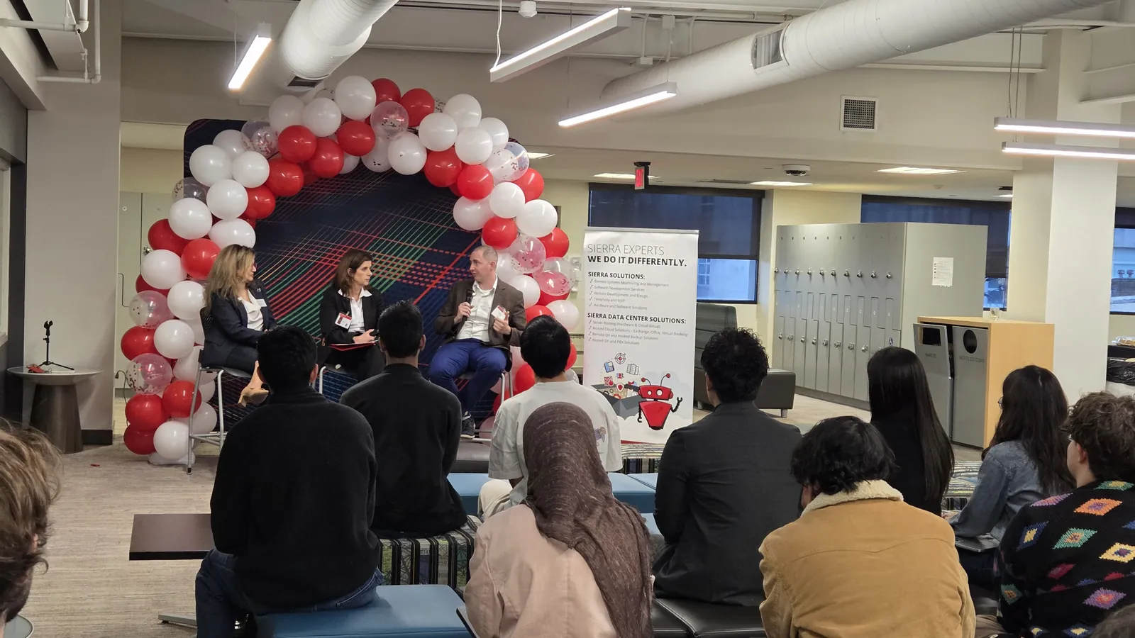Wide view of the audience on the INI student floor during the panel