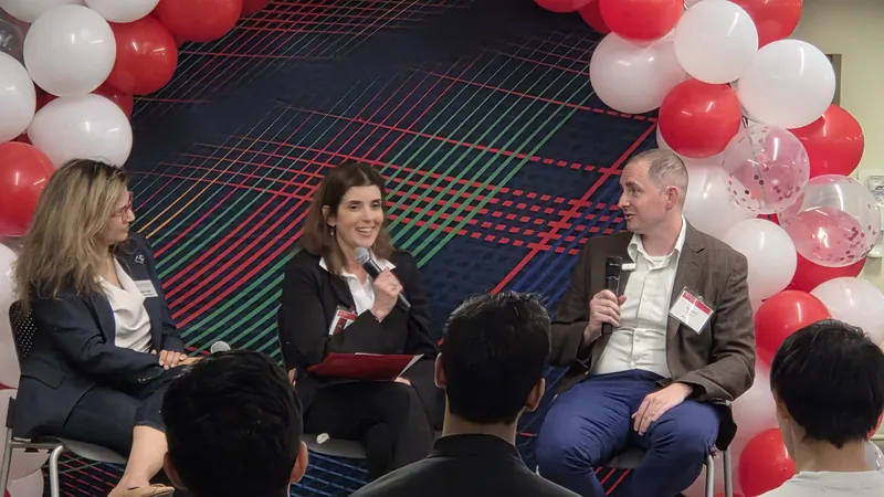 Panelists speak in front of a red and white balloon arch at the CMU INI When AI Attacks panel