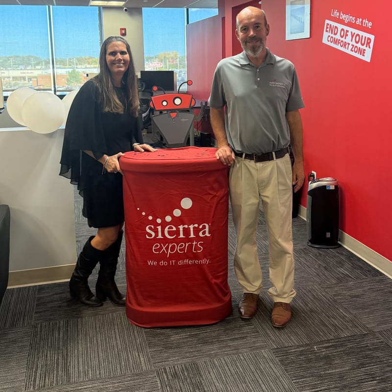 Two guests standing at a red Sierra Experts cocktail table
